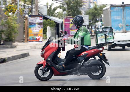 BANGKOK, THAILAND, 20 2022. FEBRUAR, Ein Lieferarbeiter fährt mit einem Lieferkarton ein Motorrad Stockfoto