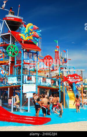 An einem Sommertag kühlen sich die Menschen in einem Wasserpark an der Küste von Jersey ab Stockfoto