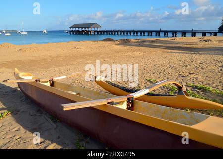 Ein Outrigger-Kanu sitzt im Sand und wartet auf das nächste Abenteuer in Hanalei Bay, Kauai, Hawaii Stockfoto