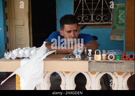 Der Mann sitzt auf der Veranda seines Hauses in Trinidad, Kuba und verkauft Eier und ist ein Lieblingsartikel für Kunden. Stockfoto