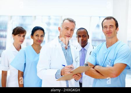Gruppe von medizinischen Fachkräften. Ein vielseitiges Team von medizinischen Fachkräften, das sich ernsthaft ansieht. Stockfoto