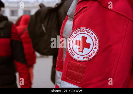 Lviv, Ukraine - 8. März 2022 : Mission des Roten Kreuzes hilft Flüchtlingen während des Konflikts in der Ukraine - Emblem auf Ukrainisch. Selektiver Fokus Stockfoto