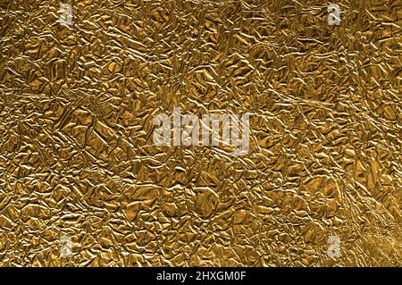 Gekrümmter goldener Metallfolie Hintergrund. Stockfoto