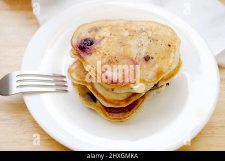 Gesunde Erdbeer- und Heidelbeer-Pfannkuchen auf einem weißen Teller Stockfoto