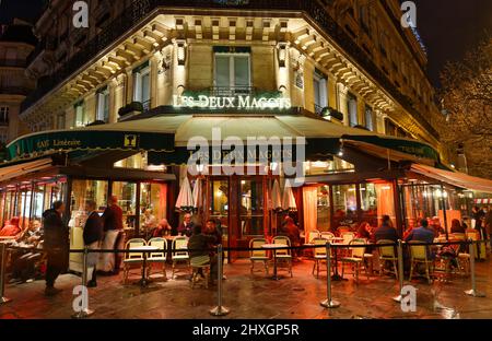 Das berühmte Café Les deux magots bei regnerischer Nacht. Es liegt am Saint-Germain Boulevard und war einst die Heimat von intellektuellen Stars, von Hemingway bis Stockfoto