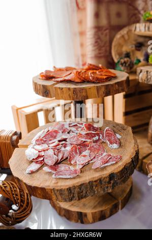 Schneiden verschiedener Fleischsorten. Fleischsnacks auf dem Tisch. Hochzeitsbuffet Stockfoto