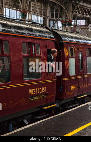 Passagiere, die aus dem Falllichtfenster in die Tür des Eisenbahnwagens der British Rail MK 1 aus den 1960er Jahren blicken, Charterzug der West Coast Railways Stockfoto