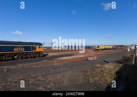 Falkland-Werft, Eisenbahngüterlokomotive der Baureihe 66 von Ayr GB, Pendlerzug der Baureihe 380 von Scotrail Siemens, Eisenbahnfräsmaschine Network Rail Schweerbau Stockfoto