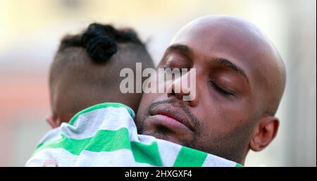 Vater umarmt Sohn, afrikanischer Vater und Kind umarmen Liebe und Zuneigung Stockfoto