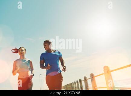 Konzentriert sich auf die Zusammenarbeit. Aufnahme eines jungen, sportlichen Paares, das gemeinsam laufen soll. Stockfoto