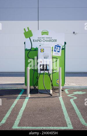 Green Electric Vehicle Rapid Charging Unit gesehen gesponsert von Lidl, Großbritannien. Stockfoto