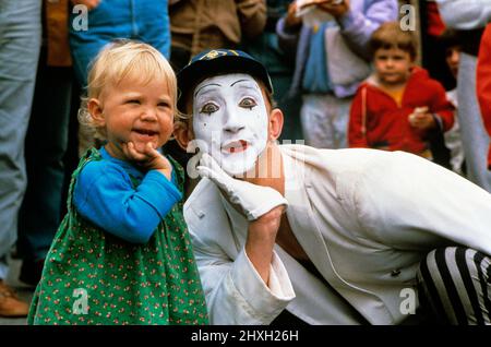 MIME, die auf der Straßenmesse auftrat, imitiert ein wenig Mädchenausdrücke und Handgesten Stockfoto