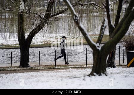 Washington, USA. 12. März 2022. Ein Mann joggt am 12. März 2022 in Washington, DC, USA, nach Schnee. Quelle: Liu Jie/Xinhua/Alamy Live News Stockfoto
