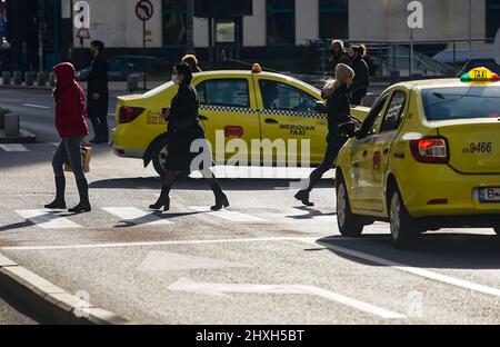 Bukarest, Rumänien - 04. Januar 2022: Fußgänger überqueren die Straße auf der Victory Avenue in Bukarest, Rumänien. Stockfoto