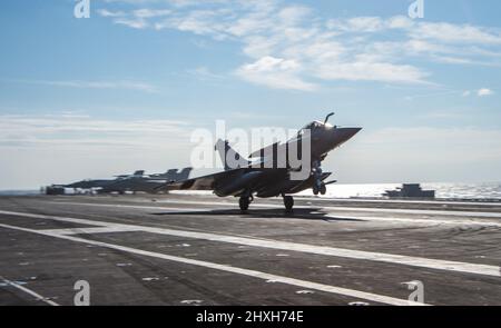 220311-N-ZE328-1409 IONISCHES MEER (MÄRZ 11, 2022) Ein französischer Rafale F-3R führt einen Touch-and-Go auf dem Flugdeck des Nimitz-Klasse Flugzeugträgers USS Harry S. Truman (CVN 75), 11. März 2022 durch. Die Harry S. Truman Carrier Strike Group ist im Rahmen eines geplanten Einsatzes im Bereich der Sechsten Flotte der USA zur Unterstützung der Interessen der USA, der Alliierten und der Partner in Europa und Afrika unterwegs. (USA Navy Foto von Mass Communication Specialist 2. Class Kelsey Trinh) Stockfoto