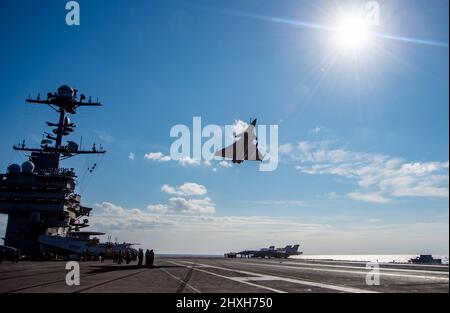 220311-N-ZE328-1359 IONISCHES MEER (MÄRZ 11, 2022) Ein französischer Rafale F-3R fliegt über das Flugdeck des Flugzeugträgers USS Harry S. Truman (CVN 75) der Nimitz-Klasse, 11. März 2022. Die Harry S. Truman Carrier Strike Group ist im Rahmen eines geplanten Einsatzes im Bereich der Sechsten Flotte der USA zur Unterstützung der Interessen der USA, der Alliierten und der Partner in Europa und Afrika unterwegs. (USA Navy Foto von Mass Communication Specialist 2. Class Kelsey Trinh) Stockfoto