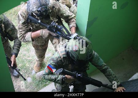 Ein US-Armeesoldat der Firma C, 2. Bataillon, 27. Infanterie-Regiment, 3. Infanterie-Brigade-Kampfteam, 25. Infanterie-Division, Und ein philippinischer Armeesoldat, der dem Kampfteam der Brigade 1. zugewiesen wurde, durchdringt die Barrikaden, um einen Raum zu räumen und das Gebäude vor gegnerischen Kräften zu sichern, während einer städtischen Geländeübung zur Unterstützung von Salaknib in Fort Magsaysay, Noueve Ecija, Philippinen, 11. März 2022. Fast 1.100 Soldaten der US-Armee im Pazifik nehmen an Salaknib zusammen mit ihren Kollegen der philippinischen Armee Teil, um die Interoperabilität zu verbessern und unsere Partnerschaft in allen Teilen der USA zu stärken Stockfoto