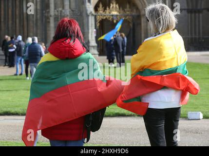 Peterborough, Großbritannien. 12. März 2022. Die Mitglieder der litauischen Gemeinde tragen bei der Gebetszeremonie Flaggen wie Umhänge. Zu einer Zeit, in der die Ukraine von Wladimir Putins Russland angegriffen wird, feiern die Litauer ihren Unabhängigkeitstag zur Wiederherstellung in der Peterborough-Kathedrale. Sie stehen zur Unterstützung der Ukraine und halten ukrainische Flaggen und Bänder fest. Am 11. 1990. März erlangte Litauen seine Freiheit aus der Sowjetunion zurück. Ein kurzes Gebet und eine Schweigeminute wurden für die gefallenen Verteidiger der Freiheit gehalten. (Foto von Martin Pope/SOPA Images/Sipa USA) Quelle: SIPA USA/Alamy Live News Stockfoto