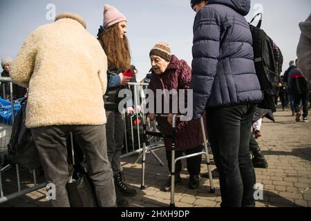 Medyka, Polen. 12. März 2022. Eine ältere Frau geht an Bord eines Reisebusses, der Flüchtlinge nach Przemysl bringt. Ukrainische Flüchtlinge am Grenzübergang Medyka am 16.. Tag der russischen Invasion in der Ukraine. Kredit: SOPA Images Limited/Alamy Live Nachrichten Stockfoto