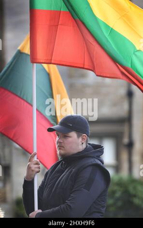 Peterborough, Großbritannien. 12. März 2022. Ein Mitglied der litauischen Gemeinschaft hält seine Nationalflagge. Zu einer Zeit, in der die Ukraine von Wladimir Putins Russland angegriffen wird, feiern die Litauer ihren Unabhängigkeitstag zur Wiederherstellung in der Peterborough-Kathedrale. Sie stehen zur Unterstützung der Ukraine und halten ukrainische Flaggen und Bänder fest. Am 11. 1990. März erlangte Litauen seine Freiheit aus der Sowjetunion zurück. Ein kurzes Gebet und eine Schweigeminute wurden für die gefallenen Verteidiger der Freiheit gehalten. Kredit: SOPA Images Limited/Alamy Live Nachrichten Stockfoto