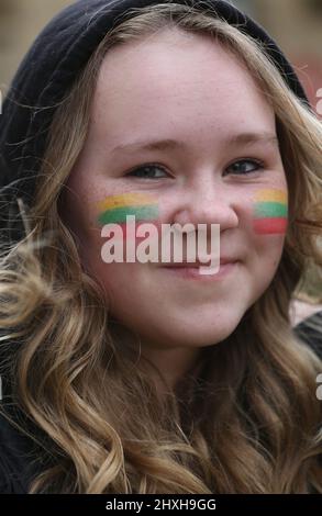 Peterborough, Großbritannien. 12. März 2022. Ein Kind mit einer litauischen Flagge auf der Wange kommt zur Gebetszeremonie. Zu einer Zeit, in der die Ukraine von Wladimir Putins Russland angegriffen wird, feiern die Litauer ihren Unabhängigkeitstag zur Wiederherstellung in der Peterborough-Kathedrale. Sie stehen zur Unterstützung der Ukraine und halten ukrainische Flaggen und Bänder fest. Am 11. 1990. März erlangte Litauen seine Freiheit aus der Sowjetunion zurück. Ein kurzes Gebet und eine Schweigeminute wurden für die gefallenen Verteidiger der Freiheit gehalten. Kredit: SOPA Images Limited/Alamy Live Nachrichten Stockfoto