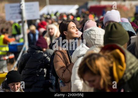 Medyka, Polen. 12. März 2022. Ukrainische Flüchtlinge stehen Schlange, um an Bord eines Reisebusses zu gehen, der Flüchtlinge nach Przemysl bringt. Ukrainische Flüchtlinge am Grenzübergang Medyka am 16.. Tag der russischen Invasion in der Ukraine. (Foto von Attila Husejnow/SOPA Images/Sipa USA) Quelle: SIPA USA/Alamy Live News Stockfoto