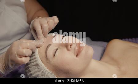 Junge hypnotische Gesichtsfrau erhält Anti-Aging-Gesichtsmassage im Spa-Salon Relax. Wellness Körper Hautpflege Gesicht Schönheitsbehandlung, Verjüngung procedu Stockfoto