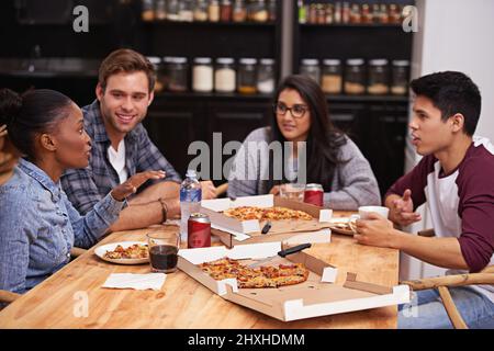 Pizza mit tollen Leuten genießen. Eine kurze Aufnahme einer Gruppe von Freunden, die zusammen Pizza genießen. Stockfoto