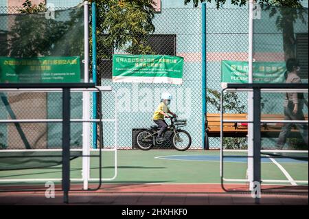 Hongkong. 01. März 2022. Ein kleiner Junge fährt mit seinem Fahrrad auf einem leeren Basketballplatz. Angesichts der zunehmenden Fälle in Hongkong hat die Abteilung für Freizeit- und Kulturdienste alle Spielplätze, Freizeiteinrichtungen, Grillplätze, Campingplätze geschlossen und sie haben begrenzte Sitzplätze an allen öffentlichen Plätzen, um Versammlungen zu reduzieren. Kredit: SOPA Images Limited/Alamy Live Nachrichten Stockfoto