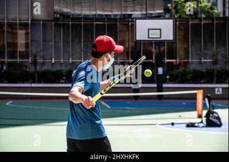 Hongkong. 01. März 2022. Zwei Herren richten ein tragbares Tennisnetz ein und spielen auf einem leeren Basketballplatz in Quarry Bay. Angesichts der zunehmenden Fälle in Hongkong hat die Abteilung für Freizeit- und Kulturdienste alle Spielplätze, Freizeiteinrichtungen, Grillplätze, Campingplätze geschlossen und sie haben begrenzte Sitzplätze an allen öffentlichen Plätzen, um Versammlungen zu reduzieren. (Foto von Ben Marans/SOPA Images/Sipa USA) Quelle: SIPA USA/Alamy Live News Stockfoto