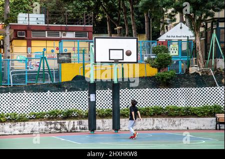 Hongkong. 01. März 2022. Ein kleiner Junge schießt auf ein Backboard ohne Netz. Angesichts der zunehmenden Fälle in Hongkong hat die Abteilung für Freizeit- und Kulturdienste alle Spielplätze, Freizeiteinrichtungen, Grillplätze, Campingplätze geschlossen und sie haben begrenzte Sitzplätze an allen öffentlichen Plätzen, um Versammlungen zu reduzieren. (Foto von Ben Marans/SOPA Images/Sipa USA) Quelle: SIPA USA/Alamy Live News Stockfoto