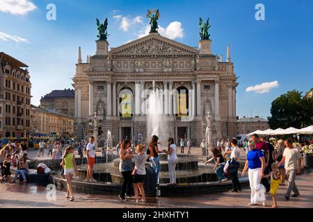 Ukrainer und Touristen entspannen sich am Brunnen vor dem Opernhaus, im Zentrum von Lviv, Ukraine Stockfoto