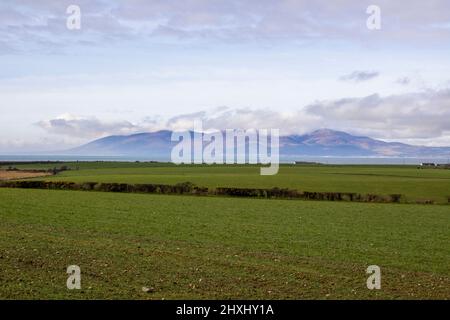 10. März 2022 Blick auf die Mourne Mountains mit ihren wolkenbedeckten Gipfeln. Blick über die Dundrm Bay vom Killough Gebiet in der Grafschaft Down Northern I Stockfoto