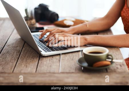 Erledigen Sie Dinge zu Hause. Eine kurze Aufnahme einer unkenntlichen Geschäftsfrau, die allein in ihrem Heimbüro sitzt und ihren Laptop benutzt. Stockfoto