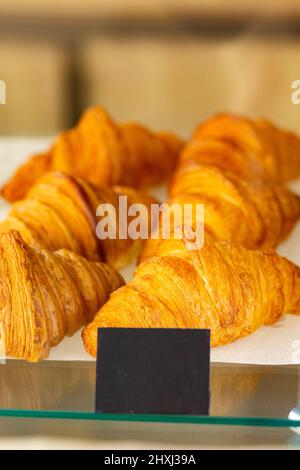 Croissant im französischen Bäckercafe im Regal gebacken, Frühstückszeit mit Croissant, französisches Frühstück, frisches Croissant am samstagmorgen gebacken Stockfoto