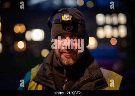 Jim, ein Feuerzeugingenieur für Gaslampen von British Gas, bereitet sich darauf vor, die mechanische Uhr der ältesten Gaslampe in England in Dean's Yard, Westminster Abbey, London, zu wickeln, die seit über 200 Jahren in Gebrauch ist und früher eine Öllampe war. In Westminster sind noch immer über 300 Gaslampen vorhanden, und rund 1.500 Gaslampen, die 200 Jahre alt sind, leuchten weiterhin die Hauptstadt. Bilddatum: Dienstag, 8. März 2022. Stockfoto