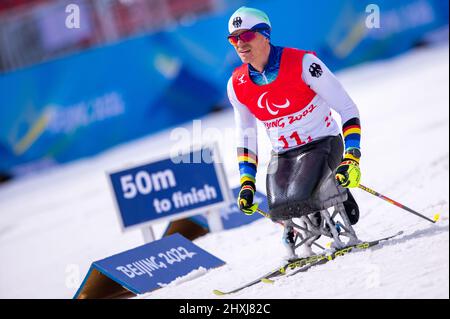 Zhangjiakou, China. 13. März 2022. Paralympics, Para Nordic Skiing, Cross-Country, Freestyle, Open Relay, Martin Fleig (Paralympische Wertung, LW 11,5 sitzend) aus Deutschland landet beim Open-Relay-Rennen über 4 x 2,5 Kilometer als Startfahrer. Das deutsche Team nimmt den Platz ein. Quelle: Jens Büttner/dpa-Zentralbild/dpa/Alamy Live News Stockfoto