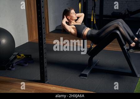 Sportliche Frau, die im Fitnessstudio bauchmuskeln trainiert Stockfoto