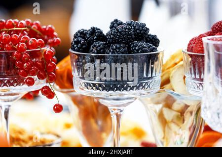 Mehrere Gläser gefüllt mit frischen Beeren der roten Johannisbeere, Brombeere und Himbeere. Beeren des Sommergartens. Stockfoto