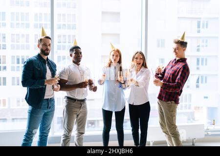 Porträt eines erfolgreichen Geschäftsteams glücklicher, multiethnischer Geschäftsleute, die auf einer Firmenfeier bengalische Lichter und Gläser Champagner halten, Stockfoto