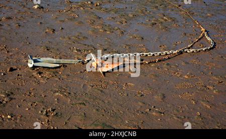 Nahaufnahme der Anker für ein kleines Boot, das bei Ebbe in einem Flutbach an der Nordnorfolk-Küste in Burnham Overy Staitthe, Norfolk, England, Großbritannien, aufgedeckt wurde. Stockfoto