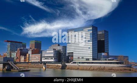 Düsseldorf, Deutschland - März 9. 2022: Blick über den Fluss auf Gebäude mit moderner futuristischer Architektur, Hyatt Hotel und Büros am Wasser agai Stockfoto