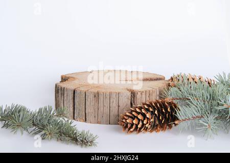 Holzständer für Waren. Stand-up. Neujahrskarte für Werbung. Baumstumpf Werbevorlage. Eine Scheibe Holz und Zapfen und Fichtenzweige. Stockfoto