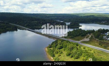 Die riesige Krimbrücke. Clip. Eine Brücke, die durch einen langen Fluss vor dem Hintergrund von Wäldern und blauem Himmel führt. Stockfoto