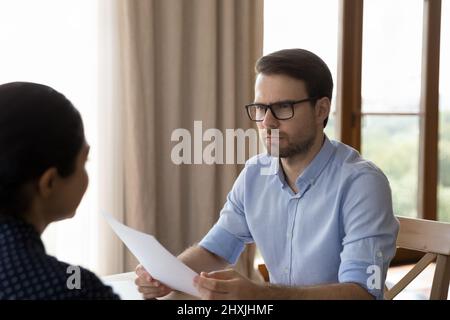 Serious aufmerksam jungen männlichen Arbeitgeber Headhunter hören weibliche Bewerber Stockfoto