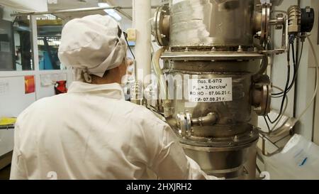 Arbeitsprozess.Clip. Produktion einer Motorenfabrik mit Arbeitern in speziellen Mänteln Stockfoto