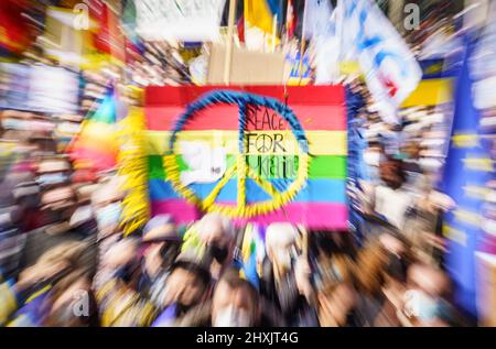 Frankfurt, Deutschland. 13. März 2022, Hessen, Frankfurt/Main: Ein Demonstrator hält ein Plakat mit der Aufschrift "Frieden für die Ukraine", während sich Tausende unter dem Motto "Stoppt den Krieg! Frieden und Solidarität für die Menschen in der Ukraine versammelten sich vor der Alten Oper (Foto mit Zoom-Effekt). Ein breites Bündnis von mehr als 50 Organisationen hatte in mehreren deutschen Städten zu Großdemonstrationen aufgerufen. Foto: Frank Rumpenhorst/dpa Quelle: dpa picture Alliance/Alamy Live News Stockfoto