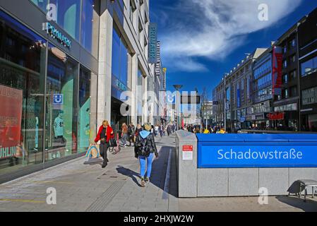 Düsseldorf (Schadowstrasse), Deutschland - März 9. 2022: Blick auf die Fußgängereinkaufsstraße und die U-Bahn-Station am sonnigen Wintertag, blauer Himmel Stockfoto