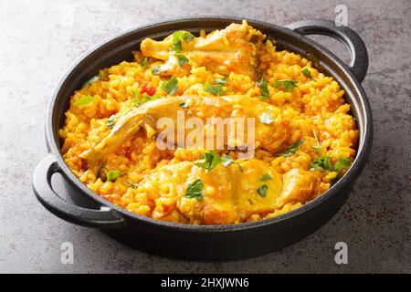 Duftender Reis mit Gemüse und Kaninchenfleisch aus der Nähe in einer Pfanne auf dem Tisch. Horizontal Stockfoto