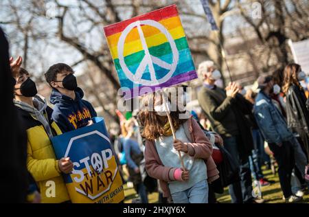 Stuttgart, Deutschland. 13. März 2022. Ein junges Mädchen hält während einer Demonstration gegen den russischen Militäreinsatz in der Ukraine ein Schild mit dem Friedenssymbol in den Händen. Quelle: Christoph Schmidt/dpa/Alamy Live News Stockfoto